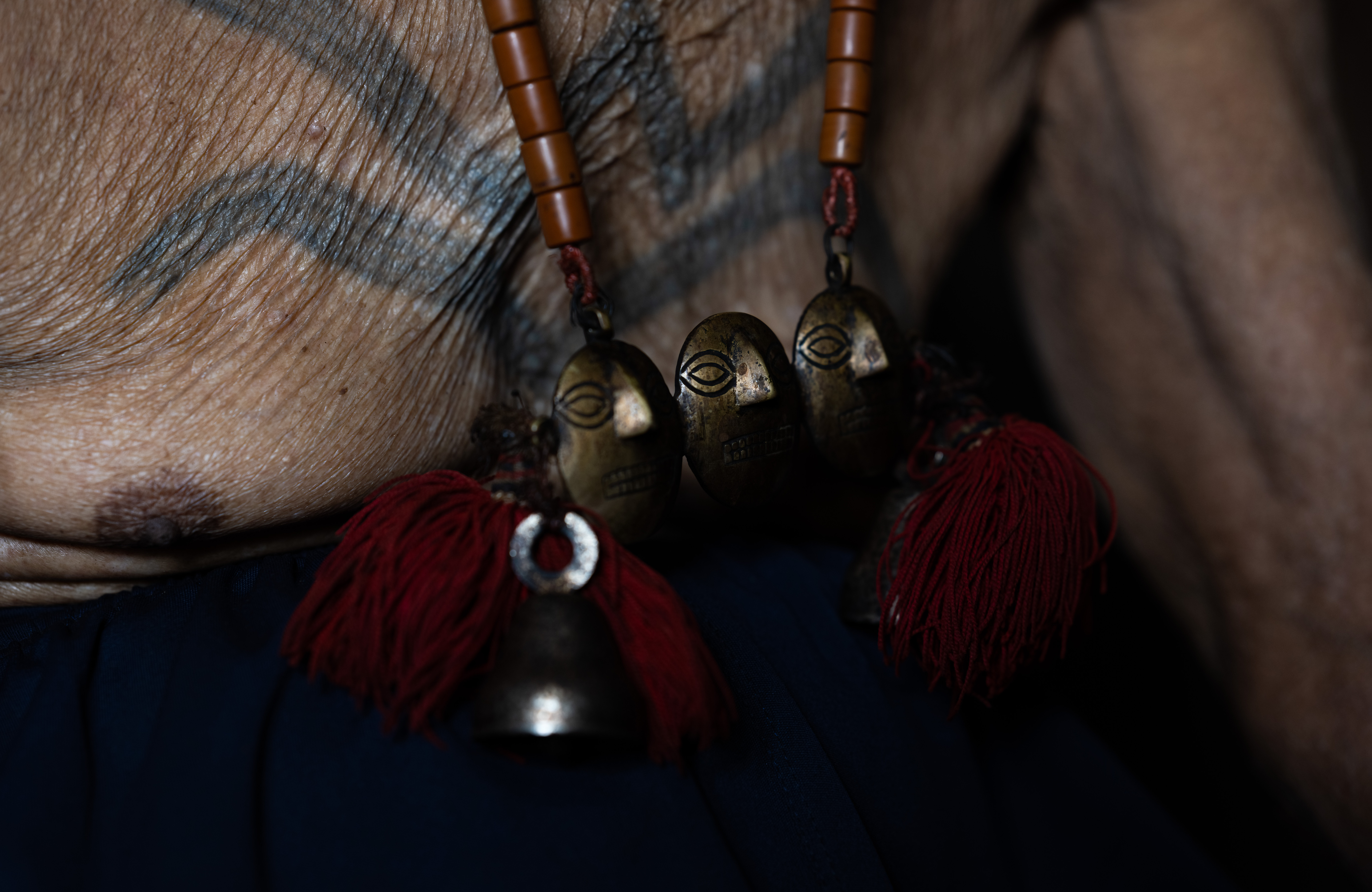 The bronze skulls worn on the necklaces are "earned" by successfully capturing the head of an enemy in battle.